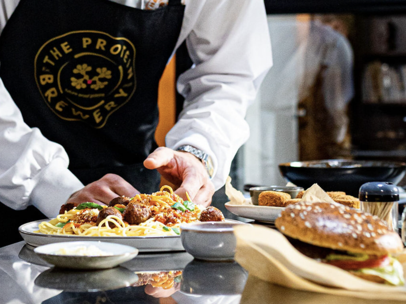 person wearing protein brewery apron preparing food